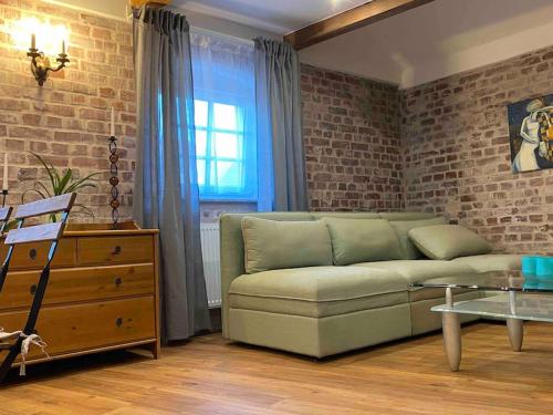 a living room with a couch and a brick wall at Fiddelhof Loft in Bad Hersfeld