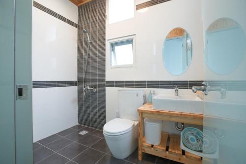 a bathroom with a toilet and a sink at Time Travel B&B in Taitung City