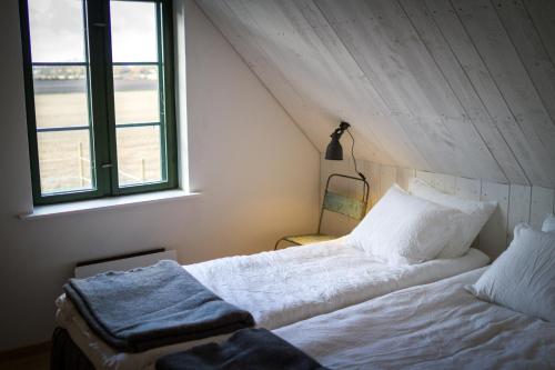 a white bed in a room with a window at Fröken Hjorts Bed and Breakfast in Höganäs