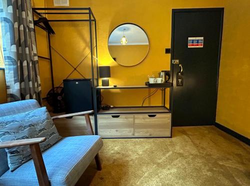 a room with a mirror and a chair and a dresser at The Earlsdale Bed and Breakfast in Ilfracombe