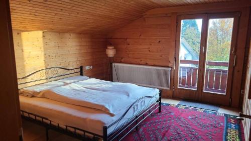 a bedroom with a bed and a large window at Ferienhaus Aida in Schwarzach