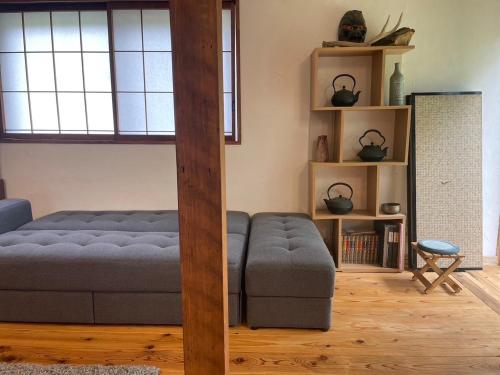 a living room with a bed and a book shelf at GETO House in Washiaimori