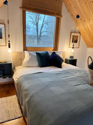 a bed in a room with a large window at Niebieski Domek nad jeziorem Mazurskie klimaty in Pogubie Tylne