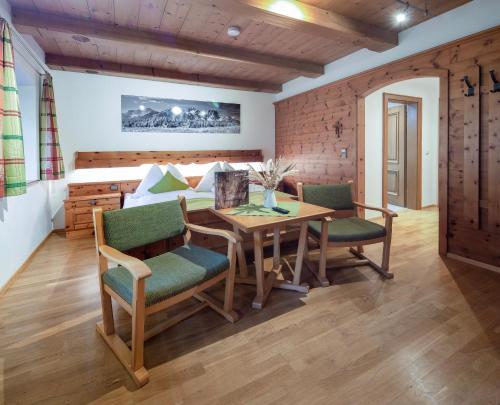 a dining room with a table and chairs and a bed at Gasthof Maria Kirchental in Sankt Martin bei Lofer