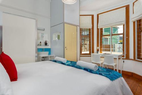 a bedroom with a large white bed and a table at At South Boutique Guesthouse in Cape Town