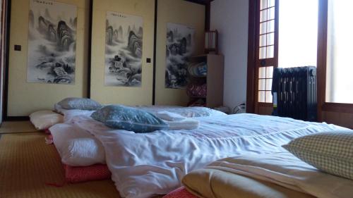 a bedroom with a large bed with pillows on it at GETO House in Washiaimori