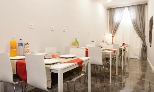a dining room with white tables and white chairs at Suites & Apartments DP VFXira in Vila Franca de Xira