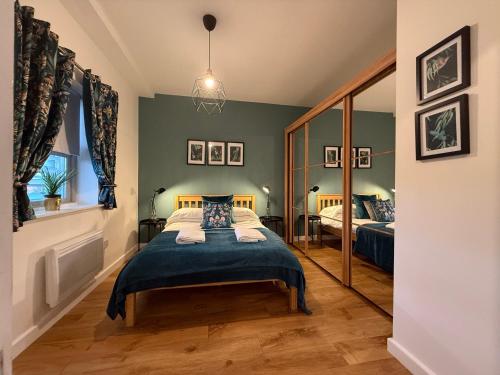 a bedroom with a bed and a mirror at Vibrant cosy 2 Bedroom Apartment in Coventry