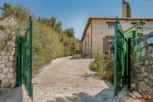 einen Eingang zu einem Steingebäude mit grünen Türen in der Unterkunft Villa Acqua, a luxury villa with private pool, 10 mins drive from the beach in Marantochori