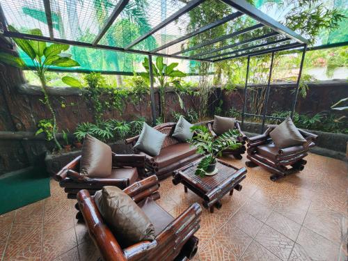 a screened in porch with chairs and a table at MB's Garden Inn in Mactan