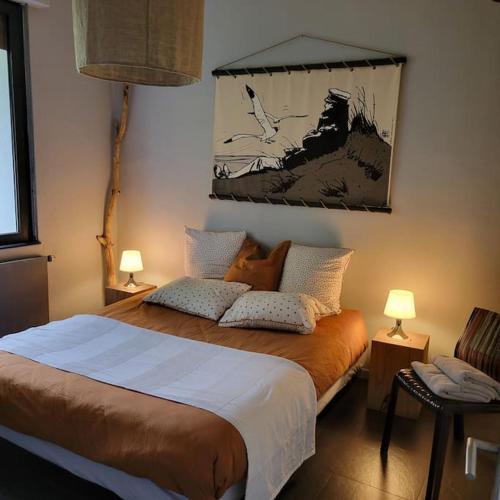a bedroom with a large bed with two lamps at Au vert chez Diane in Sparsbach