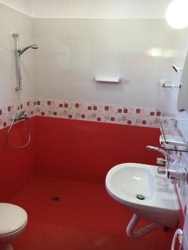 a red bathroom with a sink and a toilet at Комплекс Тянкови къщи in Varshets