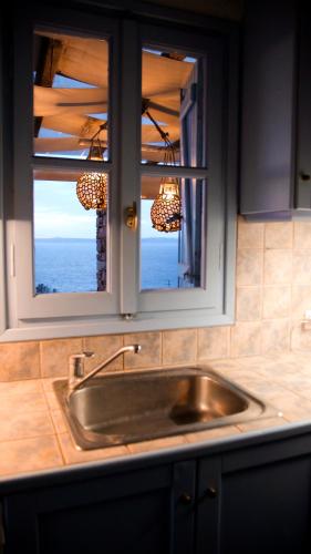 a kitchen counter with a sink and a window at Villa kèalite in Melissaki
