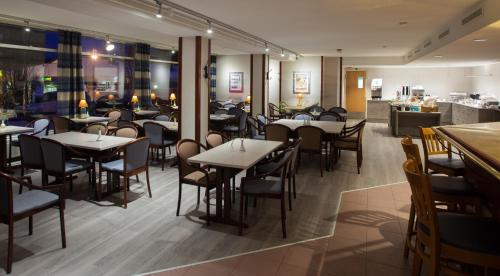 a restaurant with tables and chairs and a bar at Hotel Kauppi in Tampere