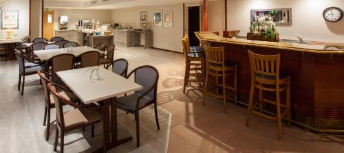 a restaurant with a bar and tables and chairs at Hotel Kauppi in Tampere