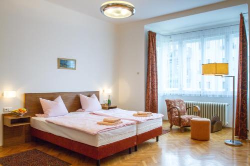 um quarto com uma cama, uma cadeira e uma janela em Pension Karnet em Praga