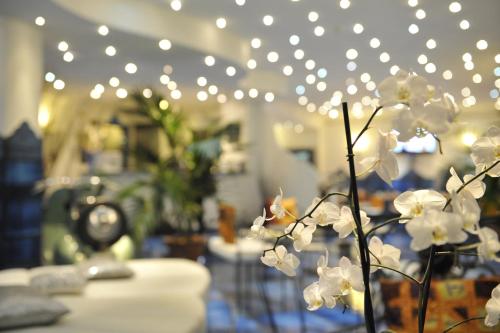 a vase with white flowers in a room with lights at Positano Art Hotel Pasitea in Positano