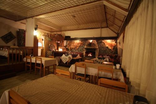 a restaurant with tables and chairs and a fireplace at Ilgaz Derbent Hotel in Ilgaz