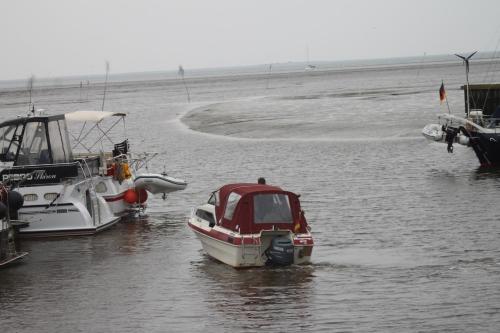 a small boat is parked in the water at Hotel Schwarzer Adler Jever in Jever