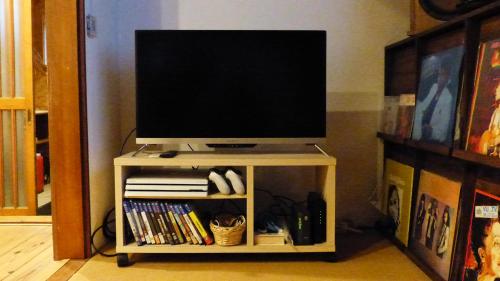 a tv on a tv stand with a television at GETO House in Washiaimori