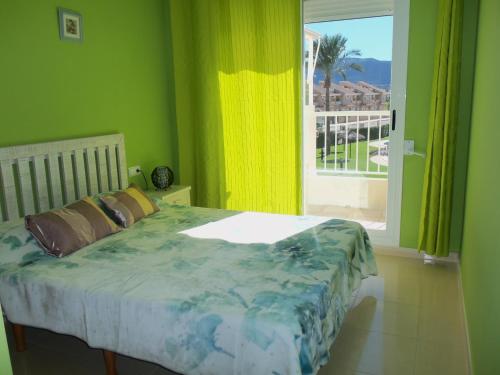 デニアにあるPlaya Sol Mediterraneaの緑の壁のベッドルーム1室(窓付)