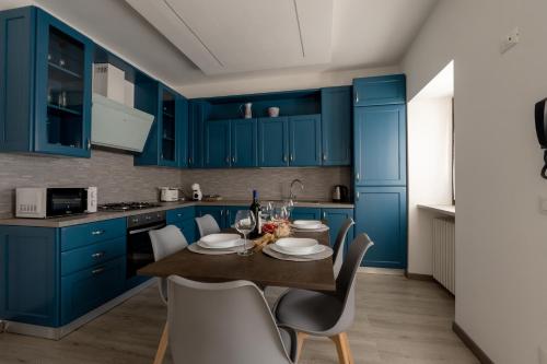 a kitchen with blue cabinets and a table and chairs at Orta Lake Mountain View - Il Fienile in Omegna