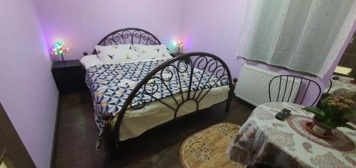 a bedroom with a bed and a purple wall at Apartament Anahita in Sinaia