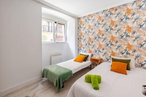 レンテリアにあるApartamento Orereta near San Sebastiánのベッド2台と壁画が備わる客室です。