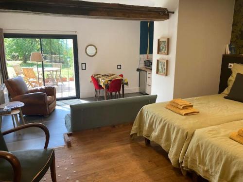 une chambre avec deux lits et une salle à manger avec une table dans l'établissement Gîte Le studio à la Ferme de Coumodous, à Montmaurin