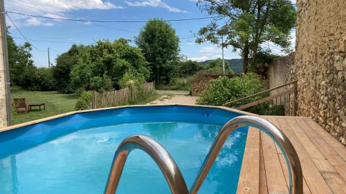 - une petite piscine bleue sur une terrasse en bois dans l'établissement Gîte Le studio à la Ferme de Coumodous, à Montmaurin