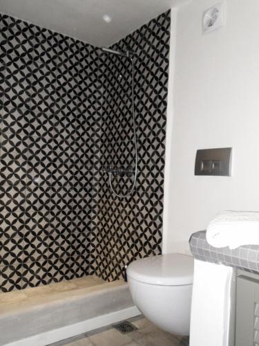 a bathroom with a toilet and a black and white wall at Sunhaus in Perissa