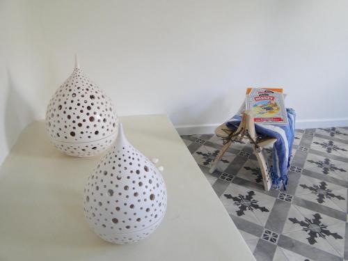 two white vases sitting on top of a table at Sunhaus in Perissa