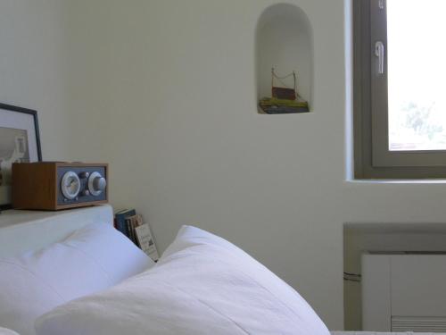 a bedroom with a bed with a speaker on top of it at Sunhaus in Perissa