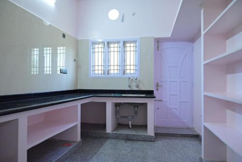 a white bathroom with a sink and a mirror at Le Joie Luxury in Puducherry