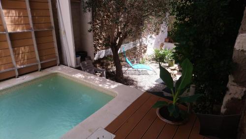 une piscine sur une terrasse à côté d'une maison dans l'établissement Maison de village avec piscine proche de Narbonne, à Moussan