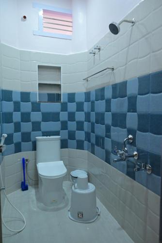 a bathroom with a toilet and blue and white tiles at Le Joie Luxury in Puducherry
