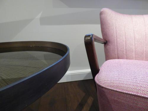 a wooden table and a chair next to a glass table and a chair at De Lindenhoeve Boutique Hotel in Sluis