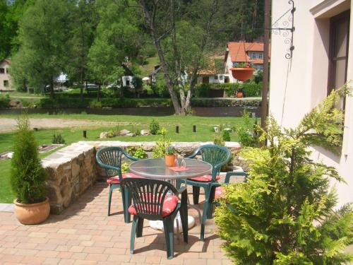 a patio with a table and chairs in a yard at Rožmberk Royale Pension in Rožmberk nad Vltavou