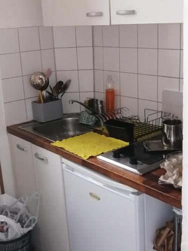 eine Küchentheke mit einer Spüle und einem Herd in der Unterkunft Appartement F2 Paris la villette 4 chemins in Aubervilliers