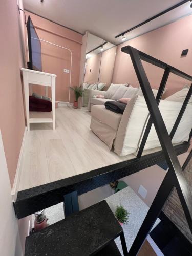 a loft bedroom with a bed and a couch at Pink42 MiniStudio2 in Budapest