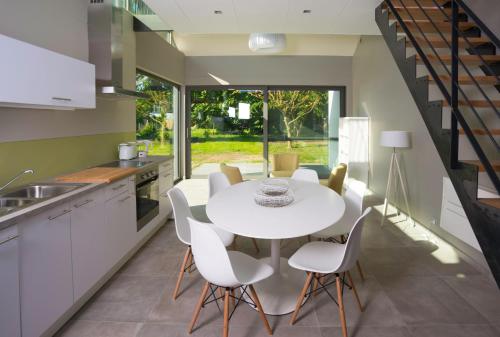 uma cozinha e sala de jantar com uma mesa branca e cadeiras em Git Émoi em Estaimpuis