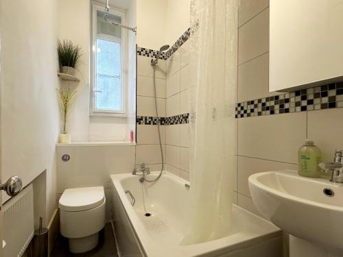 a bathroom with a tub and a toilet and a sink at Oliver's Place in Holborn - 2 Double Beds, 1 Sofa Bed, Great Location in London
