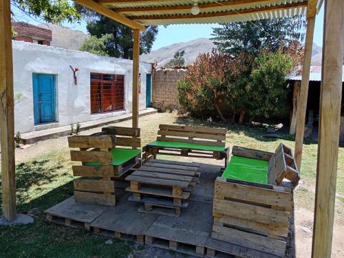 a picnic table and benches under a pavilion at Casa de campo hospedaje RyM in Sicuani