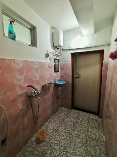 a bathroom with a shower and a door and a sink at Ratna Homestay & Restaurant in Darjeeling