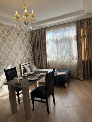 a living room with a dining room table and a couch at Idea Park Apartment in Baku