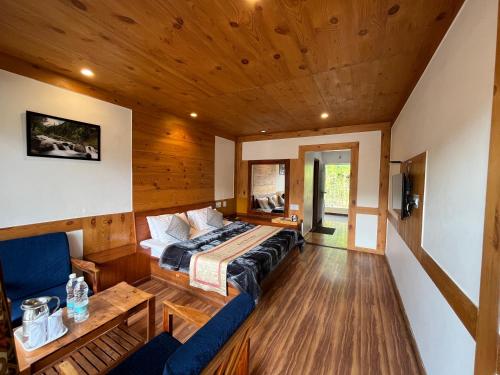 a bedroom with a bed and a couch in a room at THE CONIFER in Manāli