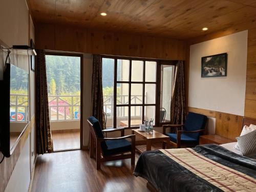 a hotel room with a bed and a balcony at THE CONIFER in Manāli