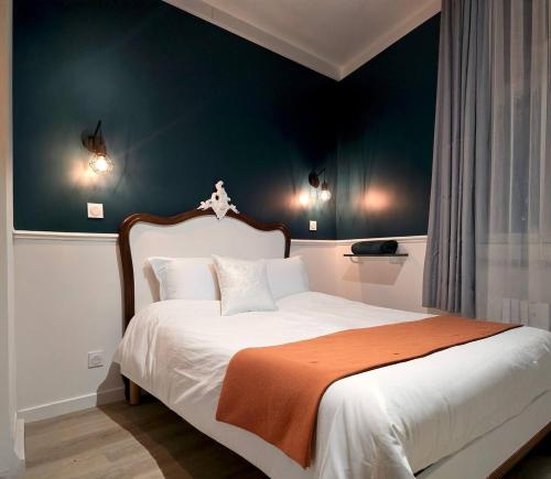 - une chambre avec un lit blanc et une couverture orange dans l'établissement Le Palazzo, à Dieppe