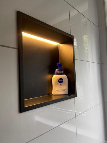 a bottle of soap sitting on a shelf in a wall at GraceHomes - Garage, Ventilator, Free Coffee, Airport, Messe, Stuttgart, WiFi up to 6 Guests in Leinfelden-Echterdingen
