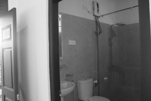 a bathroom with a shower and a toilet and a sink at Hotel SkyFall in Haputale